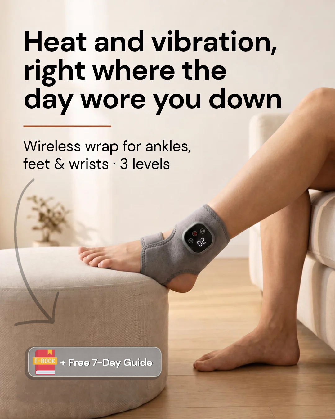 Gray wireless heat and vibration wrap worn on an ankle, foot resting on an ottoman.